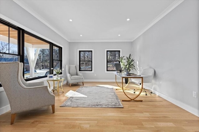 sitting room with wood finished floors, baseboards, and ornamental molding