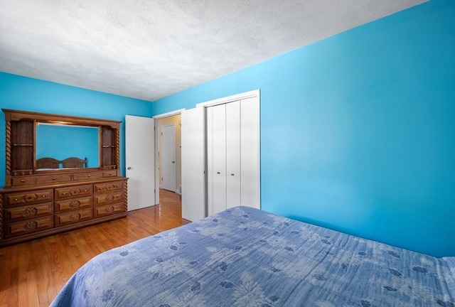 bedroom with wood finished floors, a closet, and a textured ceiling