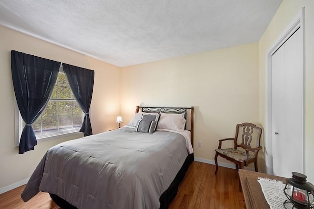 bedroom with wood finished floors and baseboards