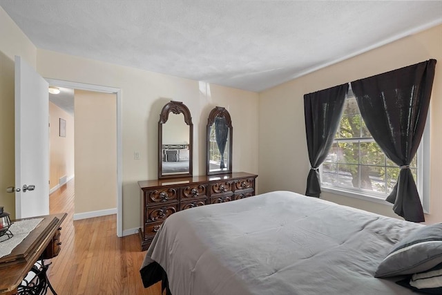 bedroom with wood finished floors and baseboards