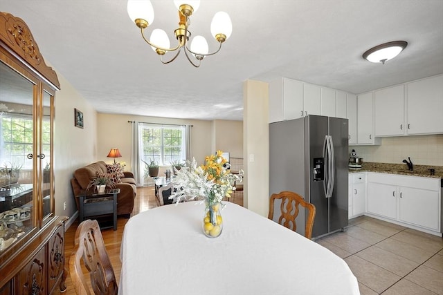 dining area with a chandelier and light tile patterned floors