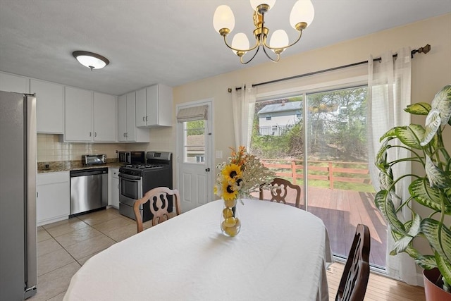 dining area with a chandelier and light tile patterned floors
