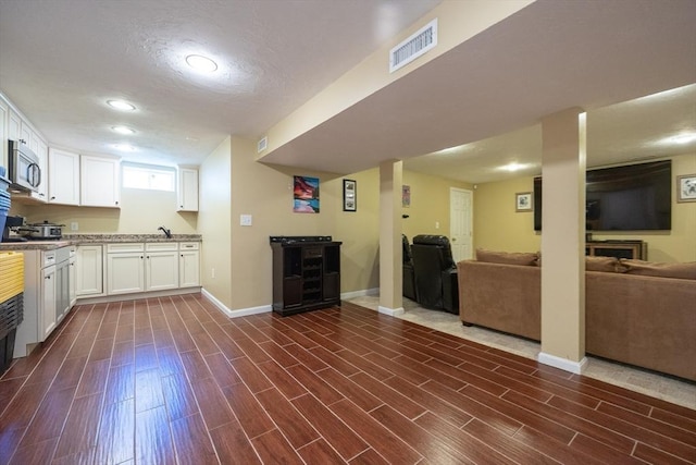 22 Hartley Ave, Brockton, MA 02302 - kitchen featuring stainless steel microwave, white cabinets, dark wood-type flooring, open floor plan, and recessed lighting