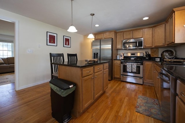 22 Hartley Ave, Brockton, MA 02302 - kitchen with appliances with stainless steel finishes, light wood-style flooring, brown cabinets, decorative light fixtures, and a center island