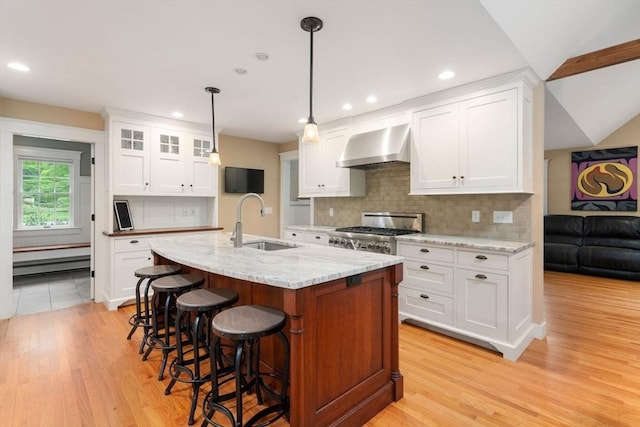 21 Autumn Ln, Marion, MA 02738 - kitchen featuring wall chimney range hood, a sink, range, light wood-style flooring, and a kitchen bar