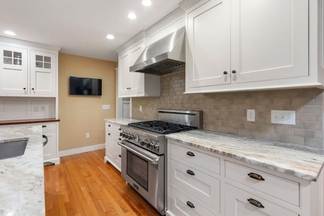 21 Autumn Ln, Marion, MA 02738 - kitchen with stainless steel range, wall chimney exhaust hood, baseboards, white cabinets, and light wood-style floors