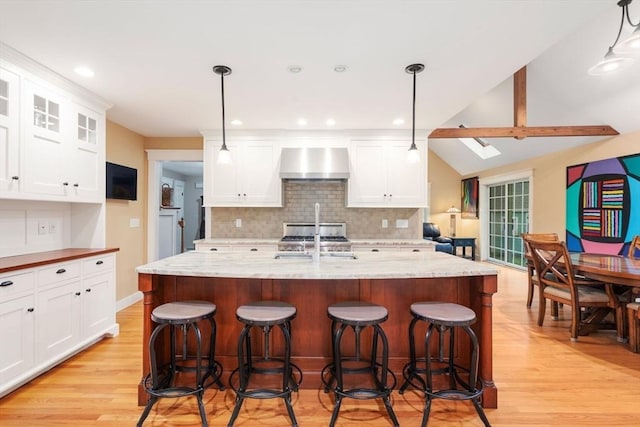 21 Autumn Ln, Marion, MA 02738 - kitchen featuring wall chimney range hood, a sink, light wood-style flooring, backsplash, and a skylight