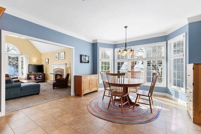 dining area with ornamental molding, light tile patterned floors, and an inviting chandelier