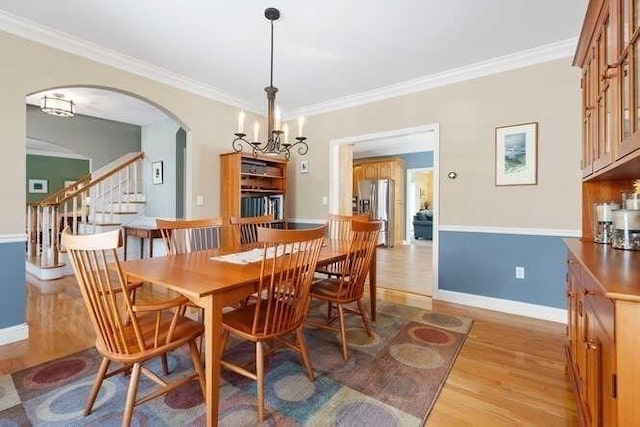 dining area featuring ornamental molding and light hardwood / wood-style flooring