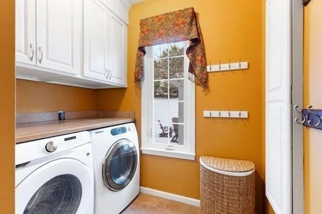 clothes washing area featuring cabinets and washer and dryer