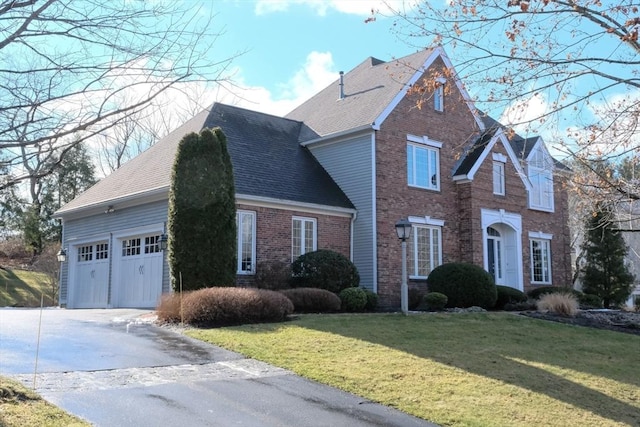 view of property with a garage and a front lawn