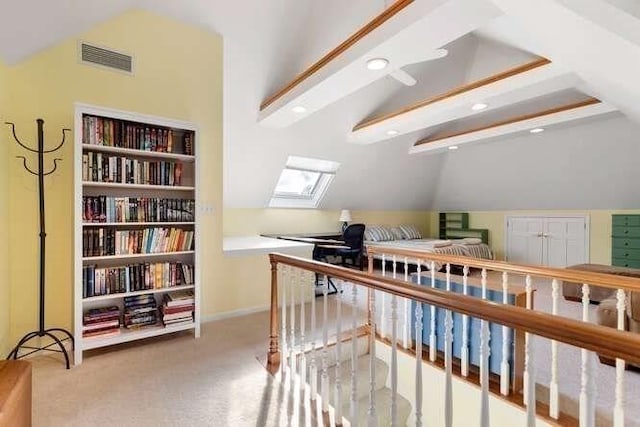 bonus room featuring built in shelves, light colored carpet, and lofted ceiling with skylight