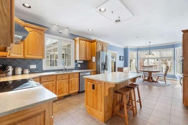 kitchen featuring sink, hanging light fixtures, a center island, light tile patterned floors, and stainless steel appliances