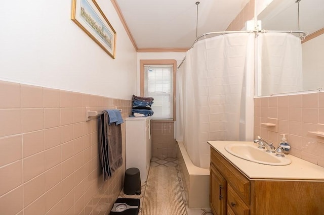 bathroom with shower / tub combo with curtain, crown molding, tile walls, vanity, and tile patterned flooring