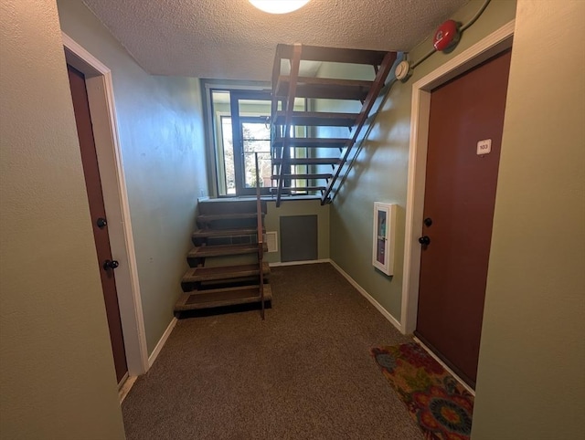 hall with baseboards, carpet floors, a textured ceiling, and stairs