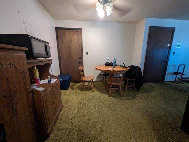 dining area with a ceiling fan and carpet floors