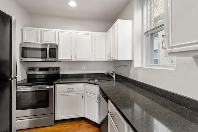 kitchen featuring stainless steel appliances, a sink, and white cabinets