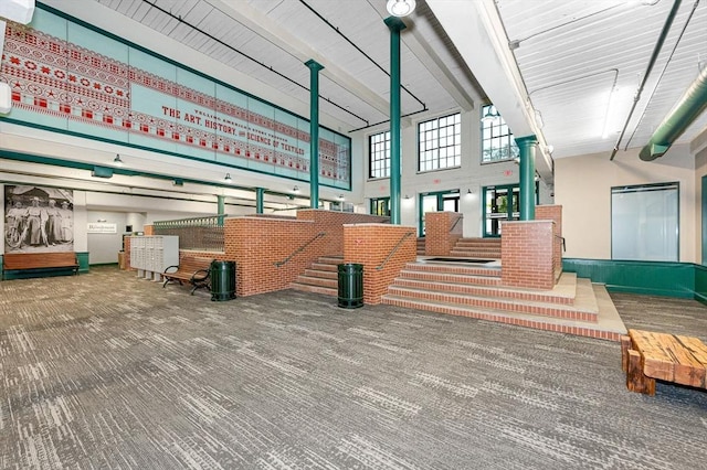 interior space featuring carpet and a towering ceiling