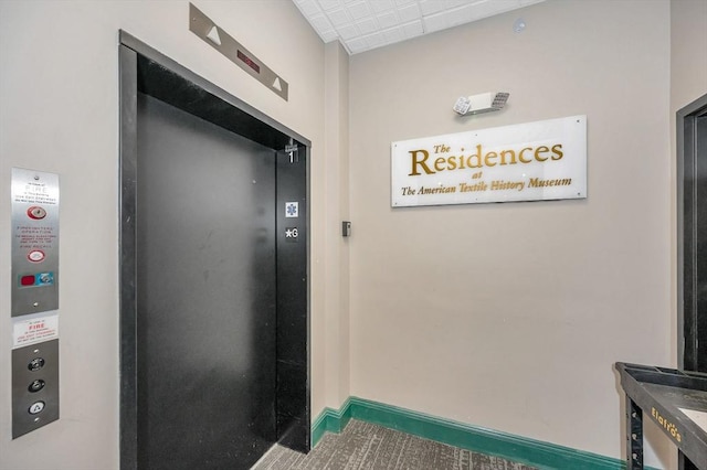 details featuring baseboards and elevator