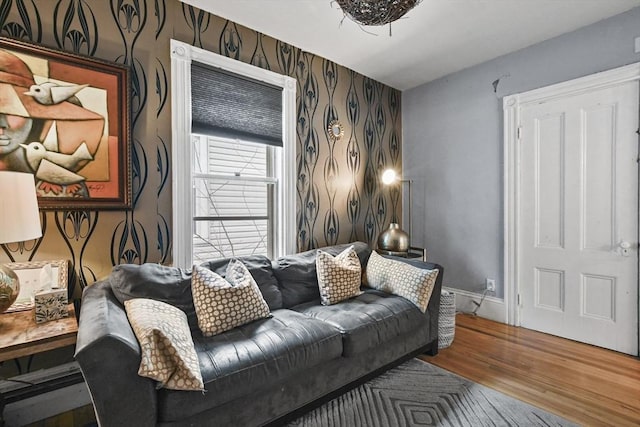 living area with wallpapered walls, wood finished floors, and baseboards