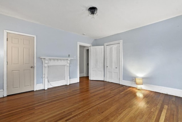 unfurnished bedroom featuring baseboards, wood-type flooring, and a closet