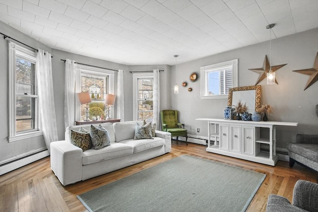 sitting room with baseboard heating, a baseboard heating unit, and wood-type flooring