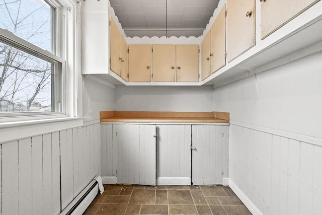 laundry area featuring a wainscoted wall and a baseboard heating unit