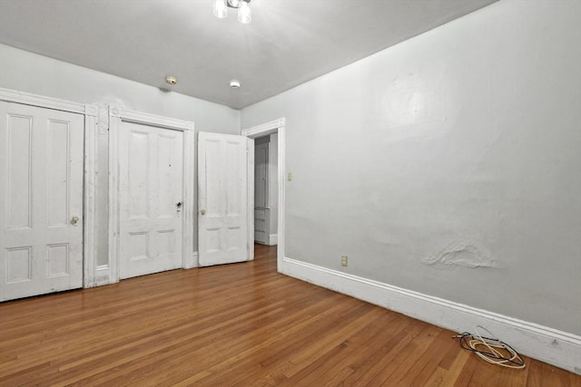 unfurnished bedroom featuring baseboards and wood finished floors