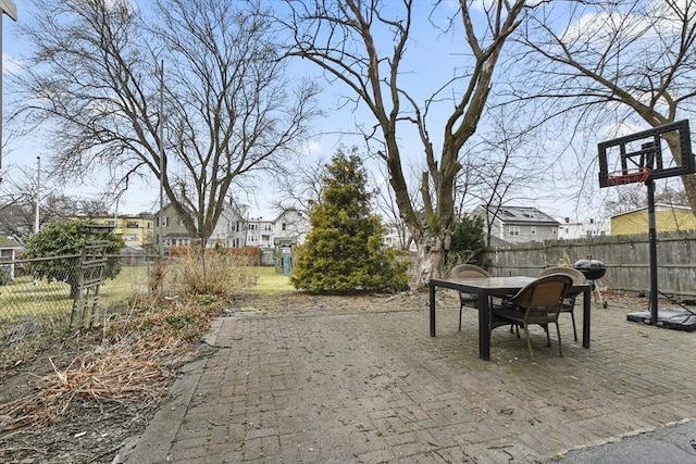 view of patio / terrace featuring outdoor dining space, a fenced backyard, and a residential view