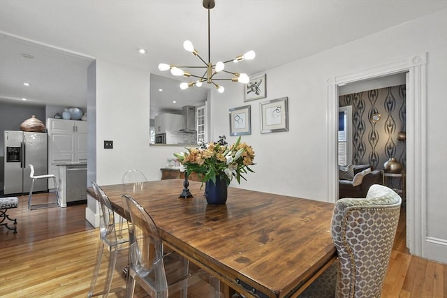 dining space with a notable chandelier, wood finished floors, and recessed lighting