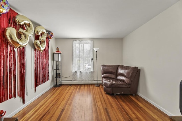 sitting room with baseboards, wood-type flooring, and baseboard heating