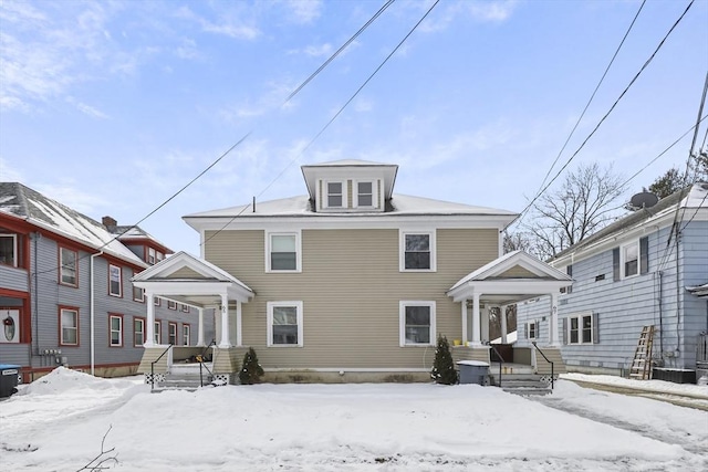 snow covered house featuring a porch