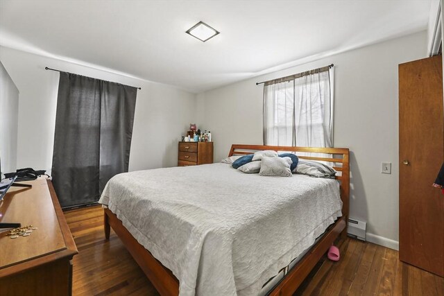 bedroom with baseboards, dark wood-style flooring, and baseboard heating