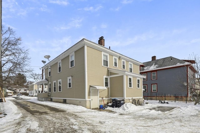 snow covered property featuring a chimney