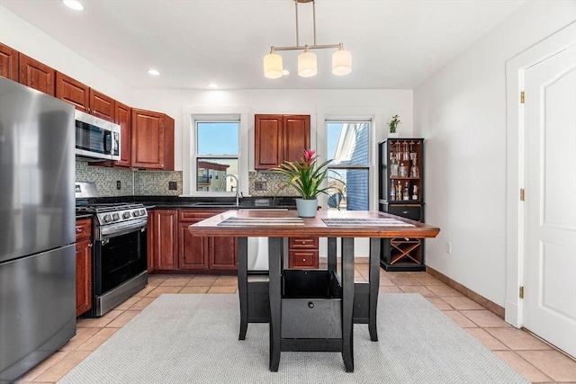 kitchen with pendant lighting, sink, decorative backsplash, light tile patterned floors, and stainless steel appliances