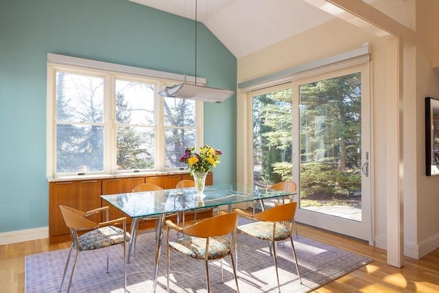 dining area featuring lofted ceiling, light hardwood / wood-style flooring, and a wealth of natural light