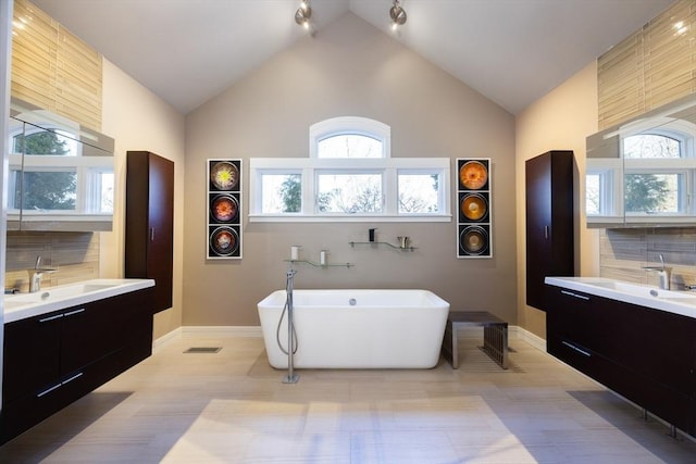 bathroom with tasteful backsplash, vanity, a bathtub, and high vaulted ceiling