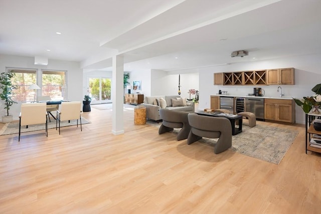 living room featuring wet bar and light hardwood / wood-style floors