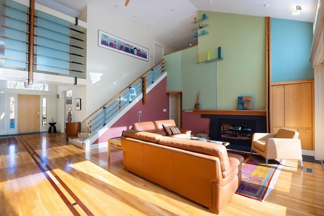 living room featuring a towering ceiling and light hardwood / wood-style flooring