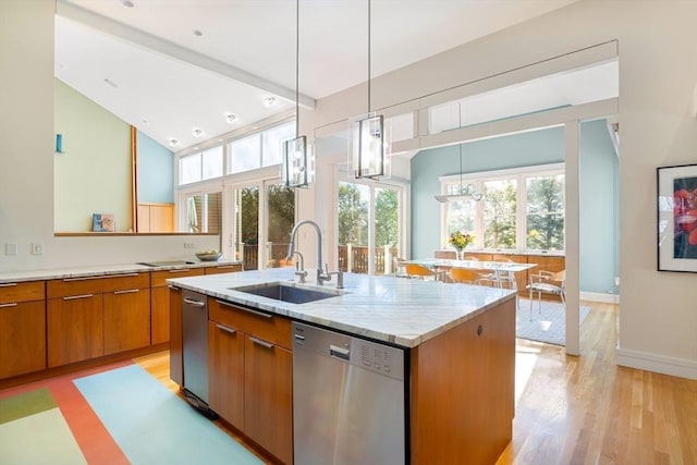 kitchen with sink, a center island with sink, stainless steel dishwasher, pendant lighting, and light stone countertops