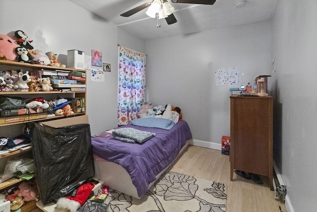 bedroom with wood finished floors, a ceiling fan, and baseboards