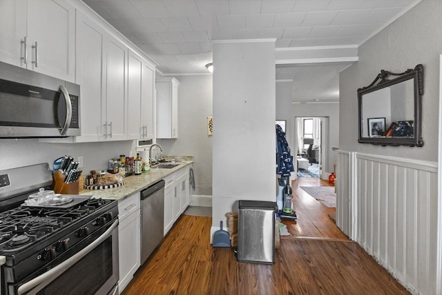 kitchen with crown molding, white cabinetry, stainless steel appliances, and dark wood-type flooring