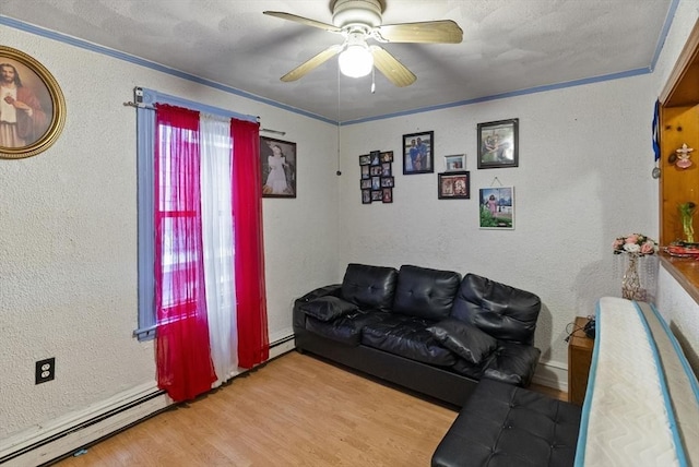 living area with a baseboard heating unit, a textured wall, ceiling fan, and wood finished floors