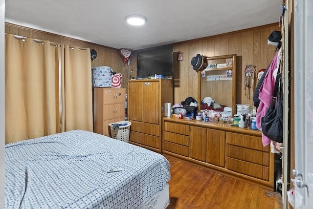 bedroom featuring wood walls and wood finished floors