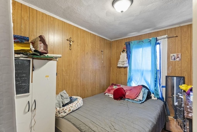 bedroom featuring wooden walls and a textured ceiling