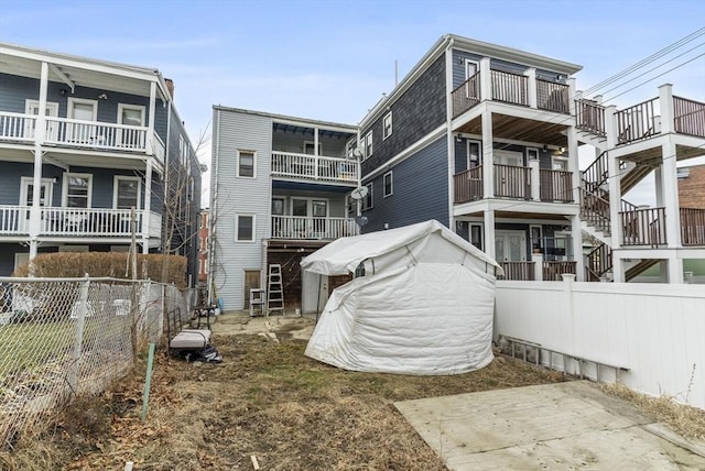 rear view of house featuring fence