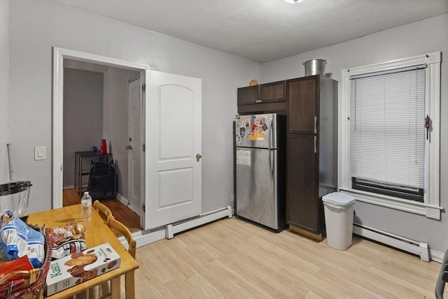 kitchen with baseboard heating, dark brown cabinetry, freestanding refrigerator, and light wood-style floors