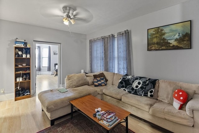 living area featuring ceiling fan, wood finished floors, and baseboards