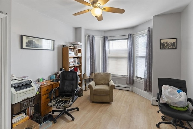 office area with ceiling fan, a baseboard radiator, light wood-style flooring, and baseboards