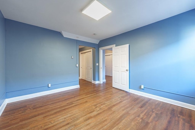 empty room featuring wood finished floors and baseboards